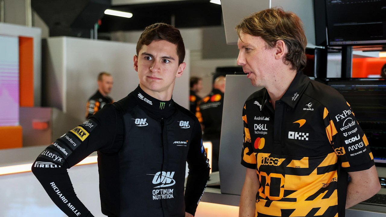 Dva mladí jezdci stojí pohromadě v týmovém oblečení Formule 1