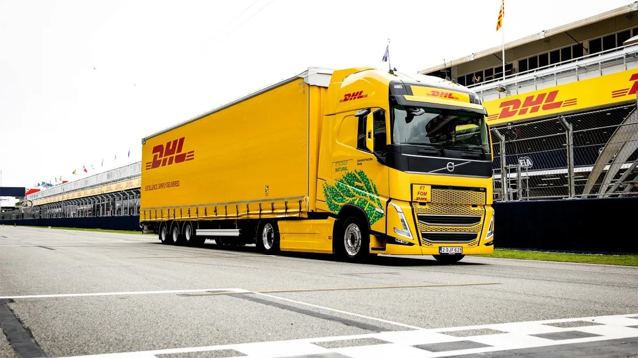 A yellow logistics truck drives through a Formula 1 circuit gate
