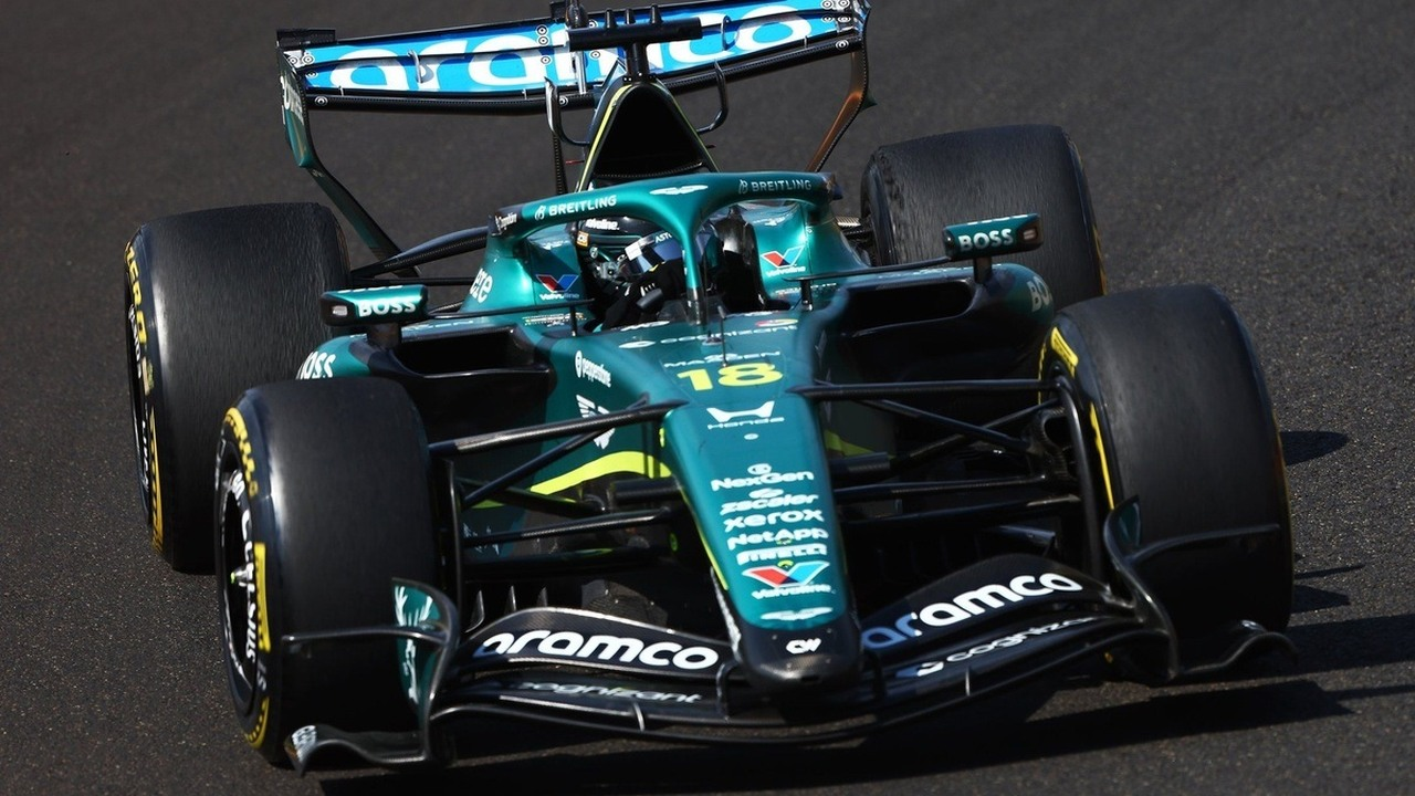 An Aston Martin Formula 1 car drives on a sunlit circuit