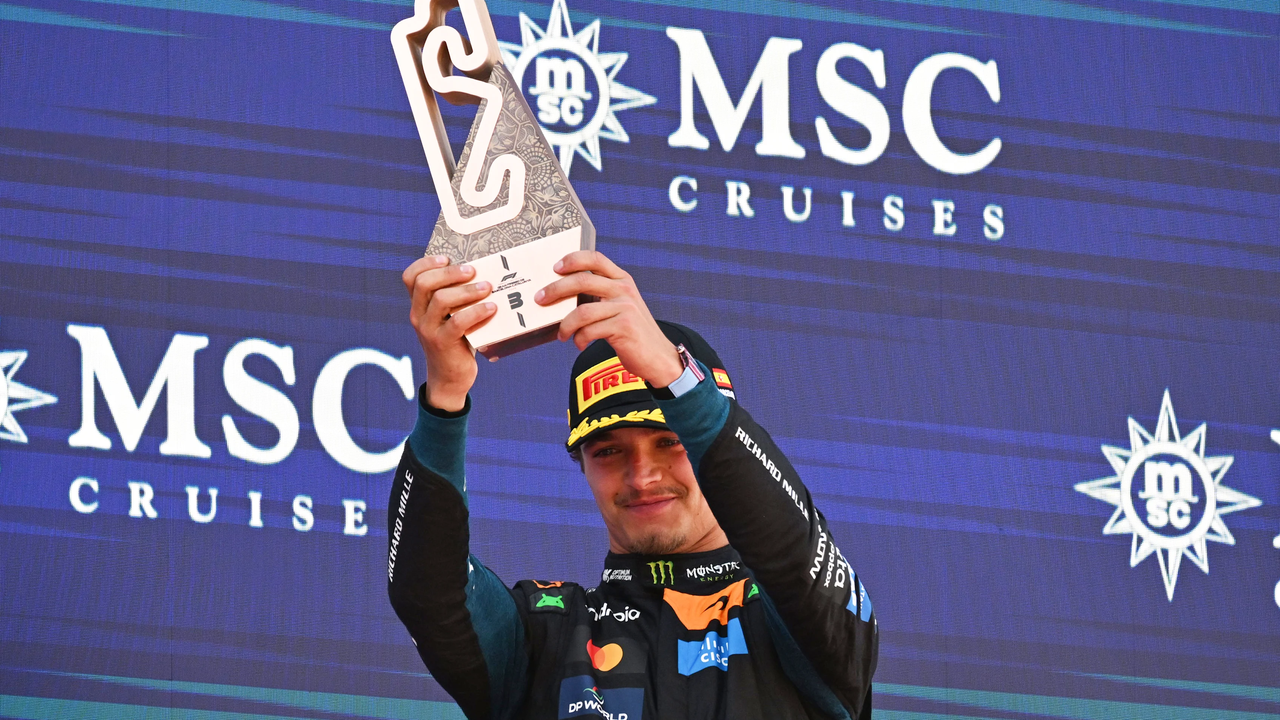 Lando Norris lifts his third-place trophy after the Barcelona-Catalunya Grand Prix