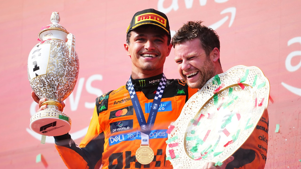 Lando Norris, McLaren komandasının üzvünün yanında Macarıstan Qran Pri kubokunu tutaraq gülümsəyir.