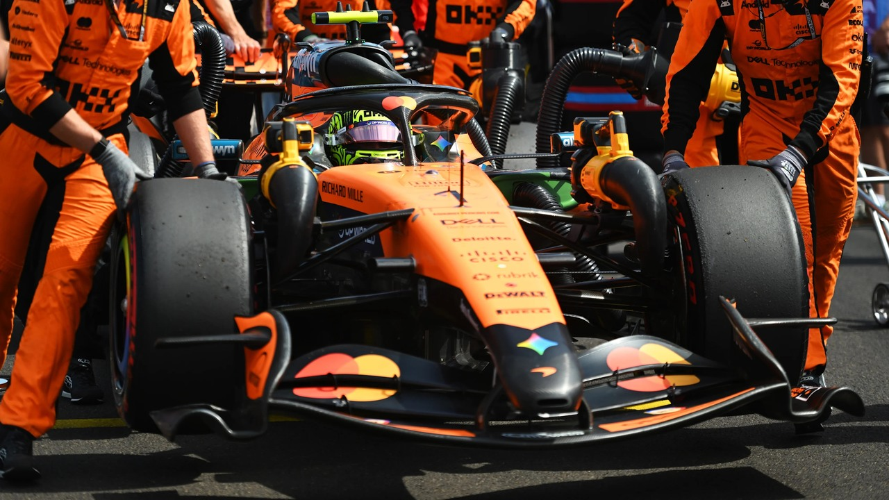 McLaren mexanikləri pit-leyndə narıncı Formula 1 avtomobilinin ətrafında işləyirlər