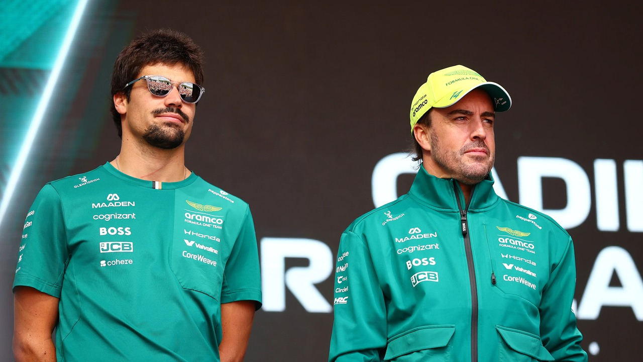 Lance Stroll and Fernando Alonso stand together in Aston Martin clothing