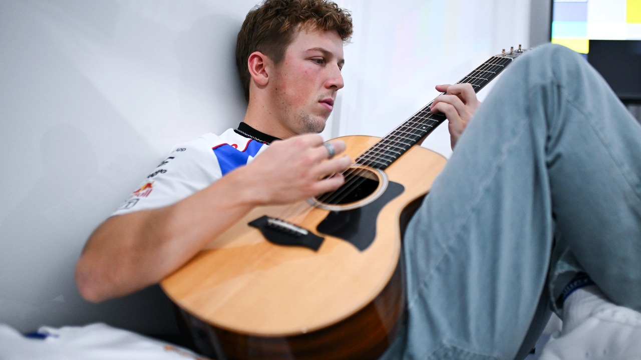 A Formula 1 driver plays a guitar during the summer break