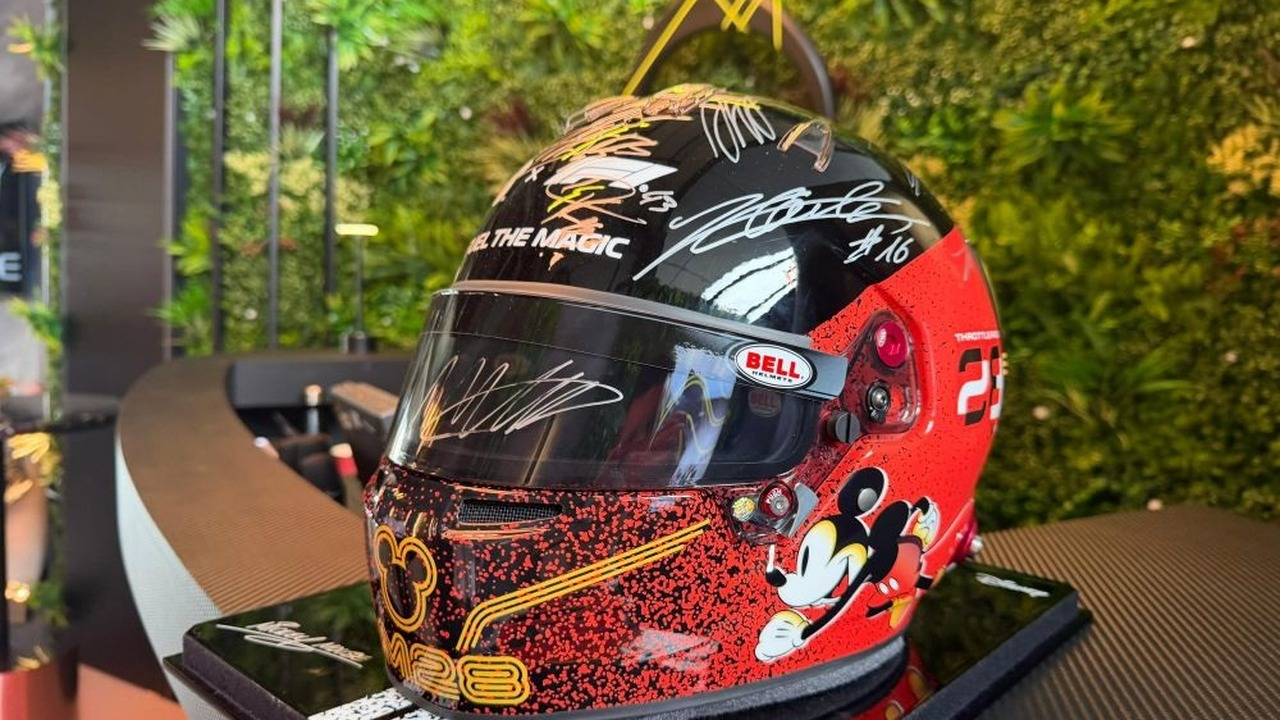 The signed Disney Formula 1 helmet rests on a display table