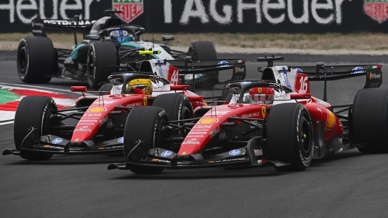 Mașinile Ferrari de Formula 1 aleargă împreună pe un circuit