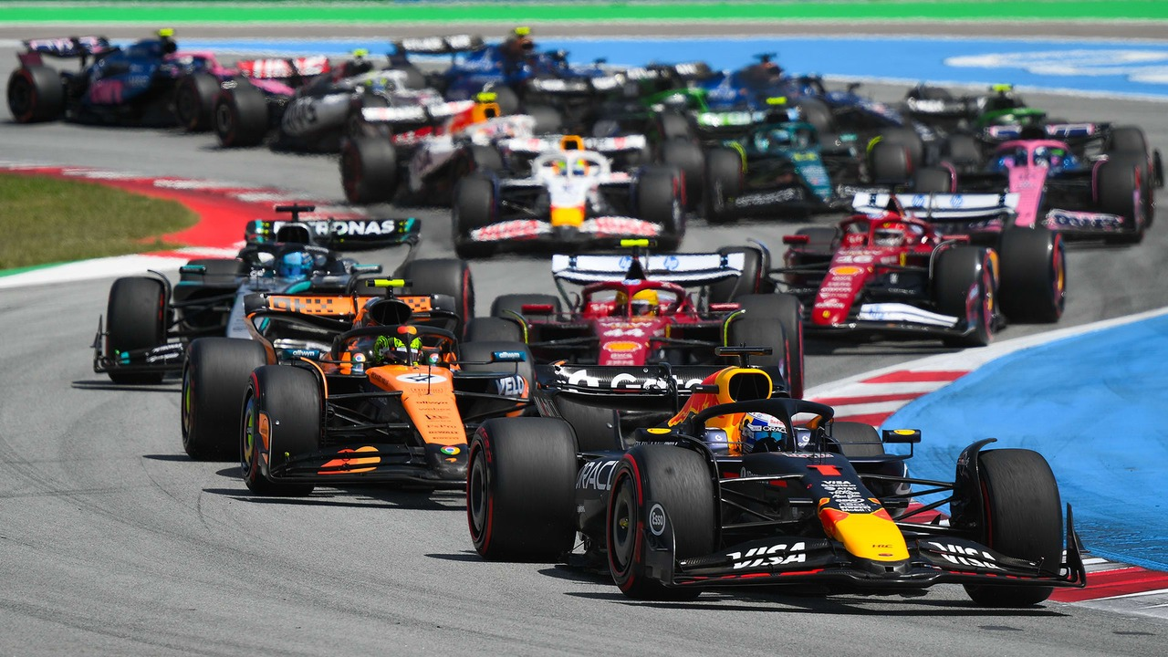 Formula 1 cars accelerate away from the starting grid