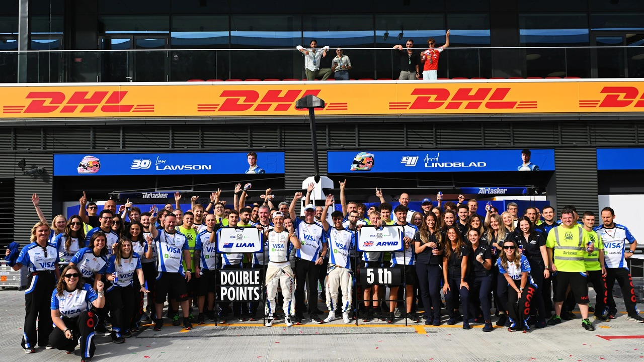 Lo staff e i piloti della Racing Bulls posano a bordo pit lane.